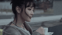 a woman holding a cup of coffee with a spoon