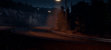 a car is driving down a road at night