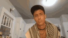 a man with a scarf around his neck and a hat on