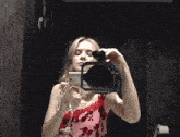 a woman taking a picture of herself with a camera