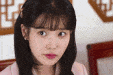 a close up of a woman 's face with the letter e visible in the background