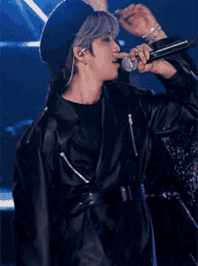 a man wearing a beret is singing into a microphone
