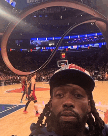 a man taking a picture of a basketball game at the madison square garden stadium