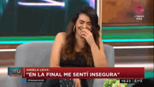 a woman is laughing in front of a tv screen that says en la final me senti inseguro
