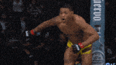 a man in a ufc shorts stands in front of a fence
