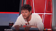 a man sitting in a chair with a nbc logo on the bottom right