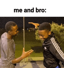 two young men are standing next to each other on a basketball court .