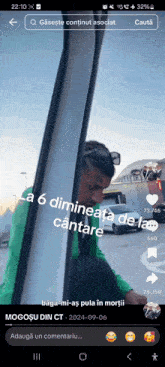 a man in a green shirt is looking out of a car window and says " la 6 dimineata de la "
