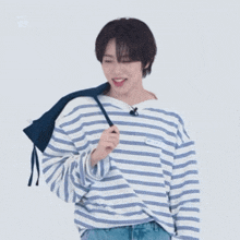 a young man wearing a striped shirt has a name tag that says ' aee ' on it