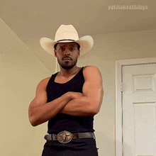 a man wearing a cowboy hat and a black tank top is standing with his arms crossed