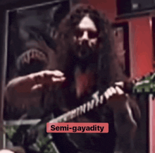 a blurred image of a man playing a guitar with the words semi-gayadity written below him