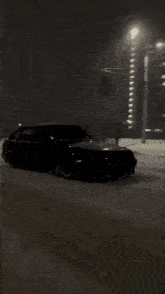 a car is driving on a snowy street at night