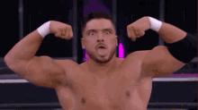 a wrestler without a shirt is flexing his muscles and sticking his tongue out