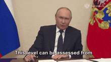 a man sitting at a desk with the words this level can be assessed from behind him