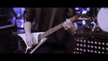 a man playing a guitar in front of a drum that says yamaha