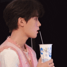 a man drinking from a cup with a straw