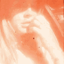 a close up of a woman 's face with a ring in her finger .