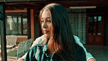 a woman is sitting on a porch with her eyes closed and a man is hugging her .
