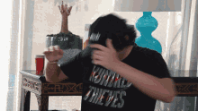 a man wearing a black shirt that says monkey thieves on it