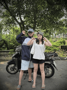a man and a woman standing next to a motorcycle