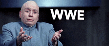 a bald man in a blue suit is making a funny face in front of a sign that says wwe