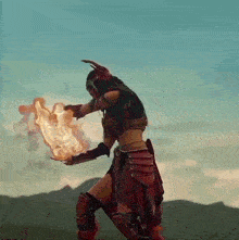a woman in a warrior costume is holding a torch in her hand