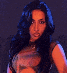 a woman with long dark hair is making a funny face with her hands