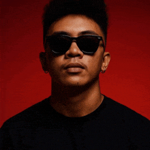 a young man wearing sunglasses and a black shirt