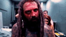 a man with dreadlocks has blood on his face and the word roh is on the bottom of the picture