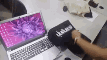 a laptop with a purple flower on the screen is sitting on a desk
