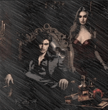 a woman in a red dress sits next to a man in a black costume