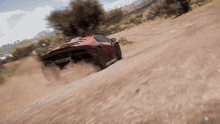 a red sports car is driving down a dirt road and has a license plate that says a-m-427