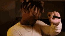 a man in a white shirt is holding a lighter in his hand .