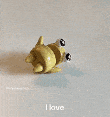 a toy with hearts on its eyes is being held by a pair of pliers .