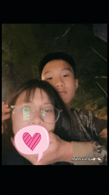 a boy and a girl are posing for a picture and the girl has a pink heart in a speech bubble