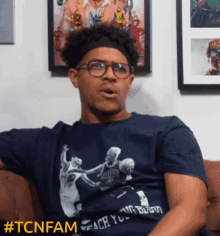 a man sitting on a couch wearing a shirt that says cavs