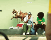 a man wearing a hat that says p.c. sits in front of a statue of a horse