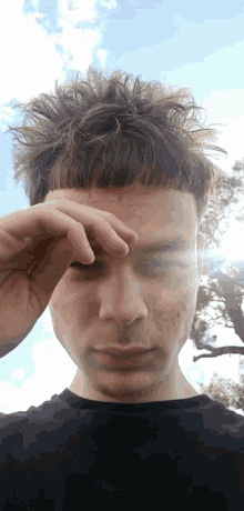 a close up of a person 's face with a hand on their forehead