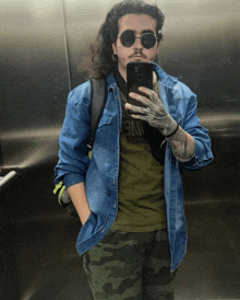 a man taking a picture of himself in an elevator wearing sunglasses and a shirt that says nike
