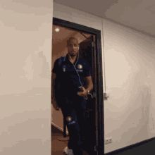 a man wearing headphones is walking through a doorway with a pepsi logo on his shirt