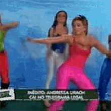 a woman in a red top and pink pants is dancing with other women
