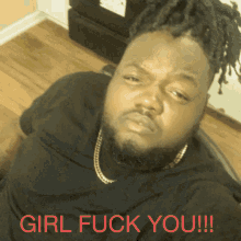 a man with dreadlocks and a black shirt with the words girl fuck you on it