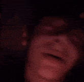 a person is covering their face with their hands in a blurry photo .
