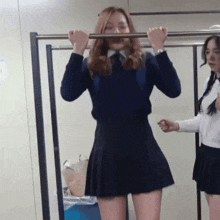 a girl in a blue sweater is hanging on a bar