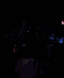 a man is singing into a microphone in a dark room with a sign that says home