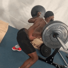 a man squatting with a barbell that has the word rogue on it