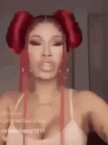 a woman with red hair is wearing a white tank top and making a funny face .