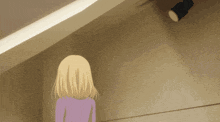 a woman in a purple shirt is standing in front of a light