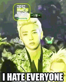 a man stands in front of a crowd with a sign that says 2012 melon music awards on it