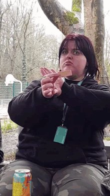 a woman sitting on a bench with a can of gatorade